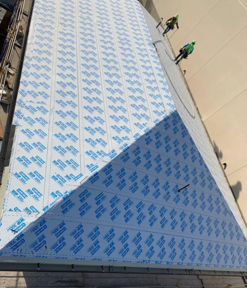 Professional roofers installing underlayment on a metal roof in Lindsay